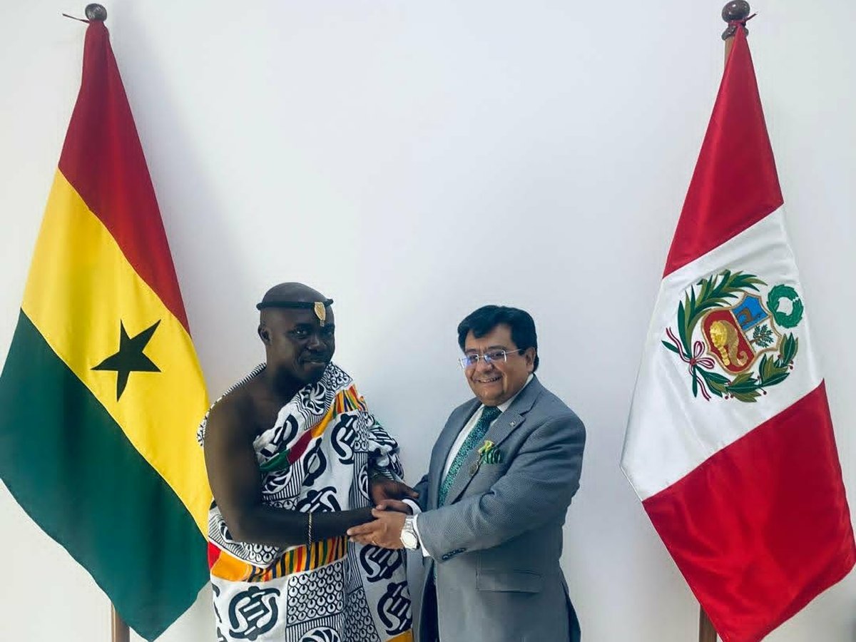 HRH Oheneba Nana Kwame Obeng II at a diplomatic engagement, between the flags of Ghana and the Republic of Peru