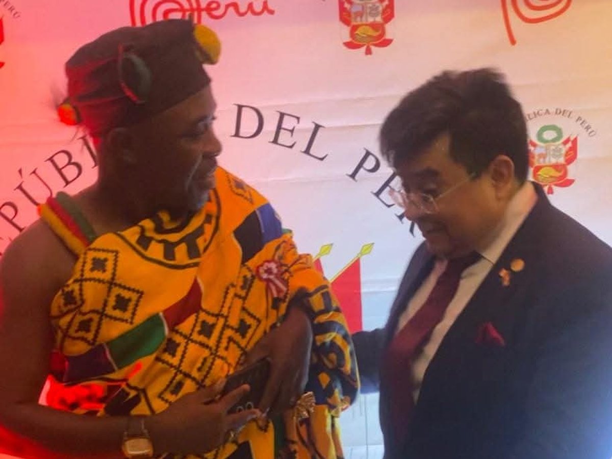 HRH Oheneba Nana Kwame Obeng II being greeted before a Republic of Peru backdrop